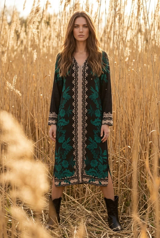 Woman wearing a black and teal floral silk midi dress with v-neck and long sleeves from Johnny Was