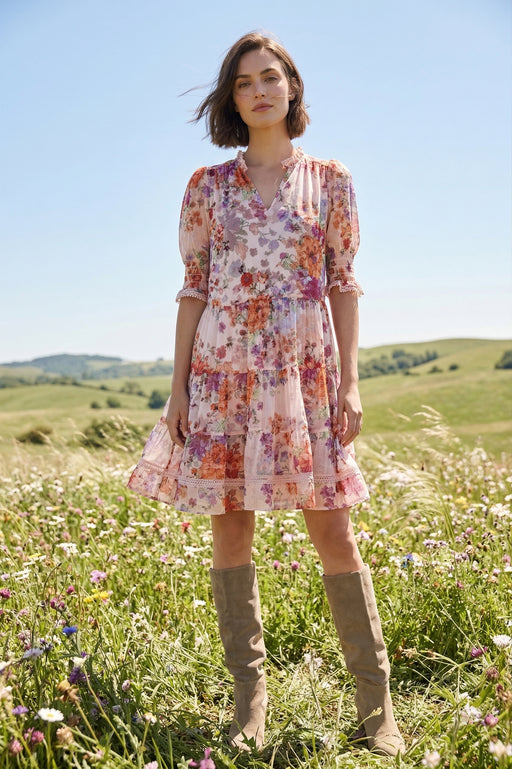 Woman wearing a floral mini dress with puff sleeves and tiered skirt from Johnny Was