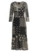 A black midi dress with three-quarter sleeves, featuring an intricate patchwork design of beige and off-white floral, geometric, and striped patterns, shown against a plain white background.