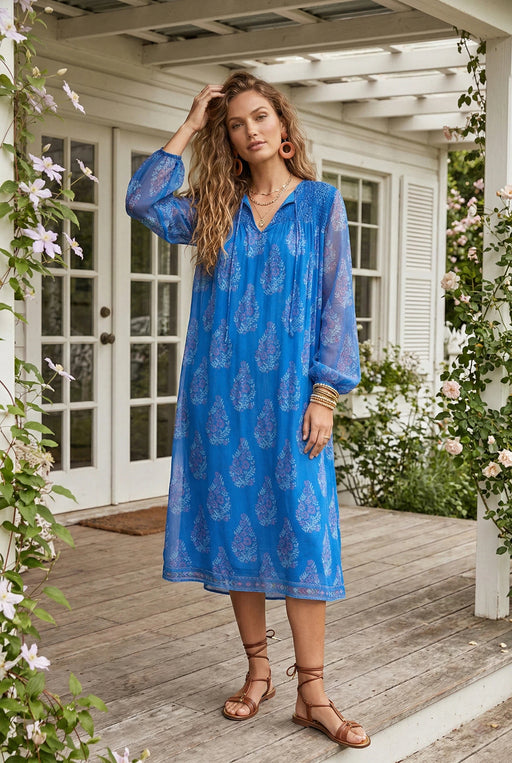 Woman wearing blue semi-sheer midi dress with floral print and long sleeves from Johnny Was