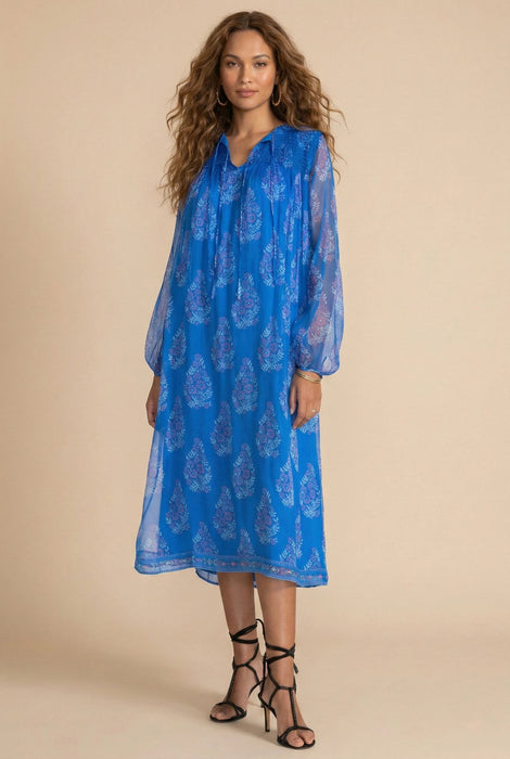 Woman wearing blue semi-sheer midi dress with floral print and long sleeves from Johnny Was
