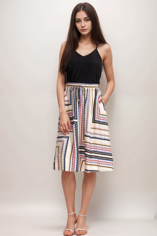 Woman wearing a geometric patterned A-line midi skirt with side pockets from Johnny Was