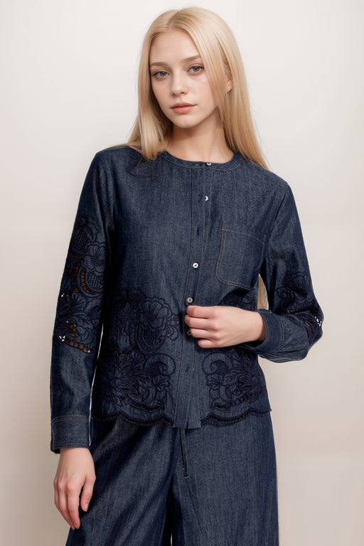 Woman wearing a dark wash denim blouse with embroidery and button front