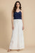 Woman wearing a white wide leg pant with pull on drawstring waistband and floral embroidered hem from Johnny Was