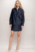 Woman wearing a dark denim shirt mini dress with tone on tone embroidery and eyelets