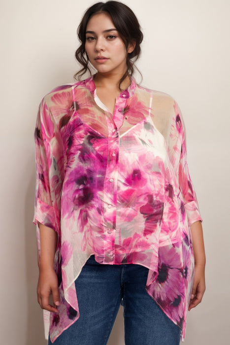 Woman wearing a pink floral sheer silk top with 3/4 sleeves and button front closure