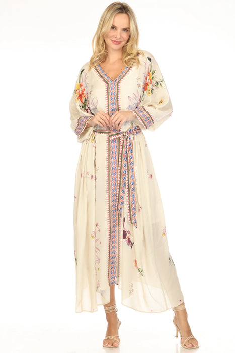 Woman wearing a long, cream-colored floral and geometric patterned maxi kaftan dress with waist tie from Johnny Was 