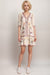 Woman wearing a floral mini dress with ruffle v-neck and tiered hem from Johnny Was