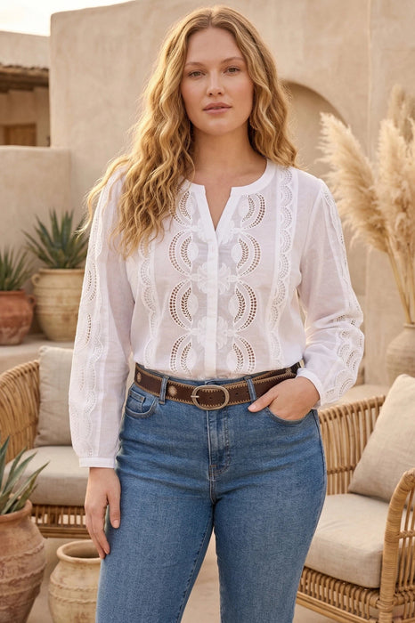 Woman wearing a white button down blouse with lace details and long sleeves from Johnny Was