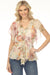 Woman wearing a floral-printed lightweight silk blouse with v-neck, drawstring waist, and flutter sleeves from Johnny Was