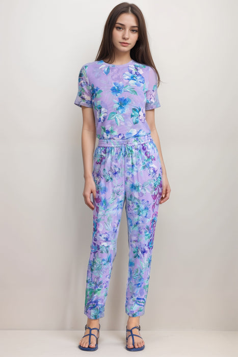 Woman wearing a purple floral jogger pant with drawstring elastic waistband from Johnny Was