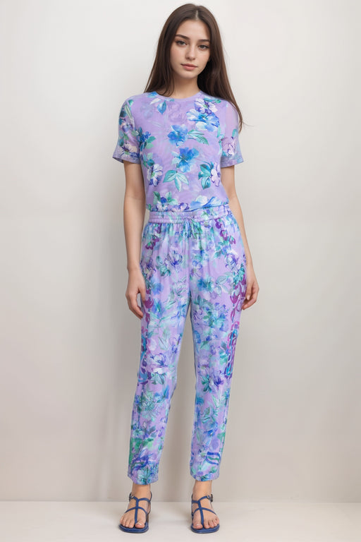 Woman wearing a purple floral jogger pant with drawstring elastic waistband from Johnny Was
