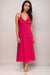 Woman wearing a bright pink halter midi dress with eyelets and embroidery from Johnny Was