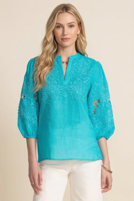 Woman wearing a turquoise embroidered blouse with split v-neck and puff sleeves from Johnny Was