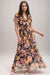 Woman wearing a colorful floral maxi dress with ruffles and v-neck