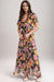 Woman wearing a colorful floral maxi dress with ruffles and v-neck