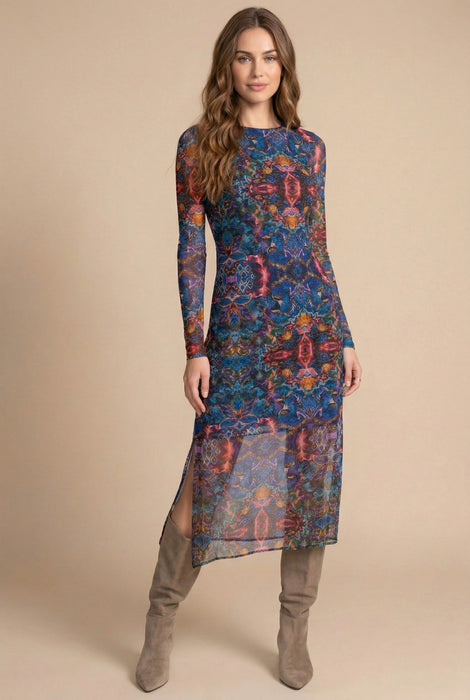 Woman wearing a colorful printed mesh midi dress with long sleeves and side slit from Johnny Was