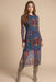 Woman wearing a colorful printed mesh midi dress with long sleeves and side slit from Johnny Was