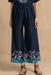 Woman wearing a navy blue cropped wide leg pants with floral print at the hem and pull on elastic waistband from Johnny Was