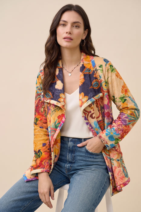 A woman models an open-front sherpa jacket with a vibrant multicolor floral print from Johnny Was