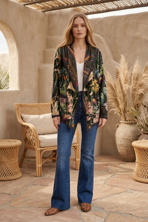 Woman wearing a colorful floral patterned hooded jacket with front pockets and long sleeves from Johnny Was