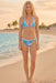 Woman wearing a matching blue printed bikini top and bottom from Johnny Was