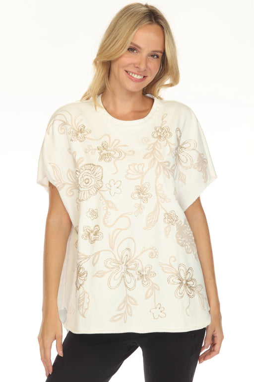 Woman wearing a white French terry poncho top with floral placement embroidery from Johnny Was