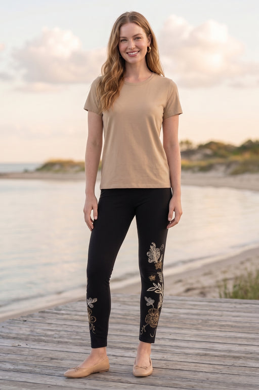 Woman wearing a black leggings with contrasting floral embroidery along the sides from Johnny Was