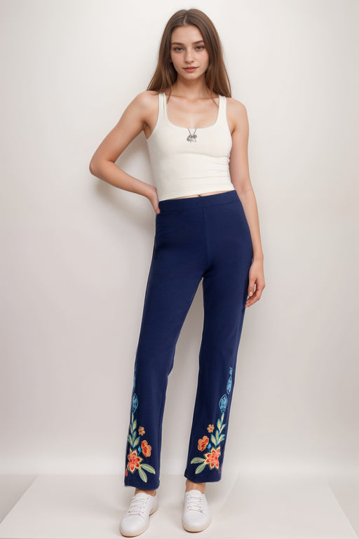 Woman wearing navy legging with floral embroidery and bootcut leg from Johnny Was