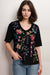Woman wearing a black floral-embroidered t-shirt with v-neck from Johnny Was