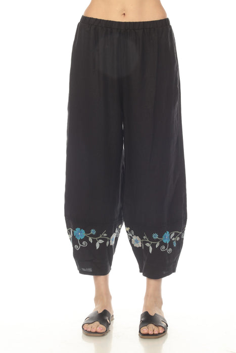 Woman wearing a black linen pant with cropped barrel leg and embroidered hem from Johnny Was