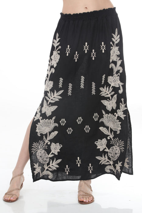 Woman wearing a black floral embroidered maxi skirt from Johnny Was