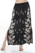 Woman wearing a black floral embroidered maxi skirt from Johnny Was