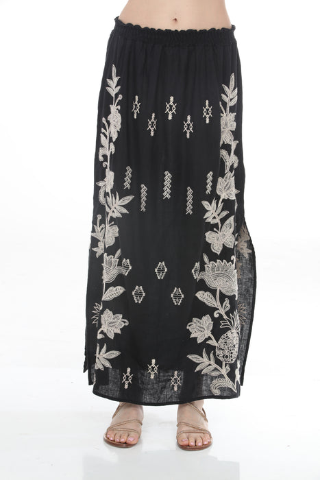 Woman wearing a black floral embroidered maxi skirt from Johnny Was