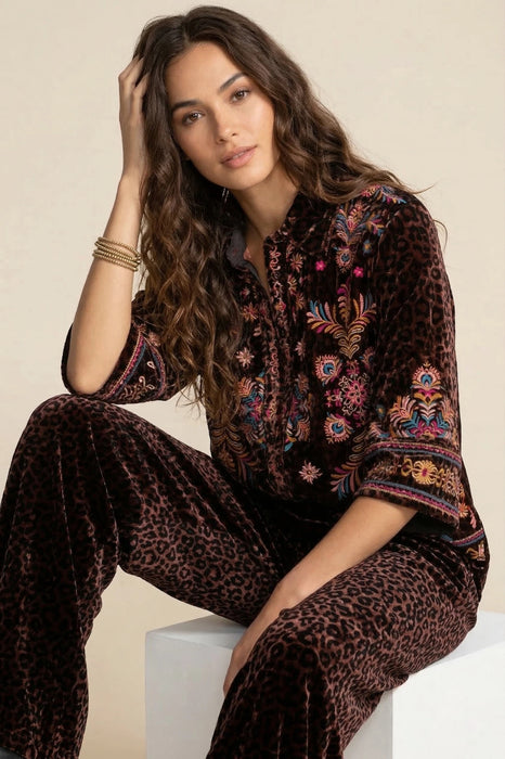 Woman wearing a leopard patterned 3/4 sleeve shirt with colorful embroideries from Johnny Was