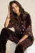 Woman wearing a leopard patterned 3/4 sleeve shirt with colorful embroideries from Johnny Was