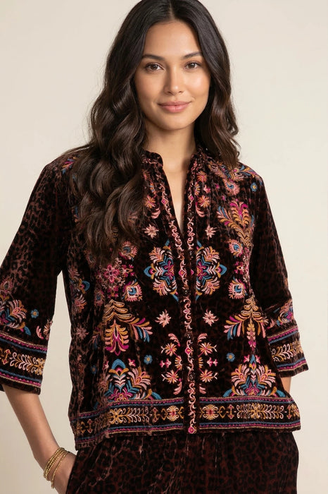 Woman wearing a leopard patterned 3/4 sleeve shirt with colorful embroideries from Johnny Was