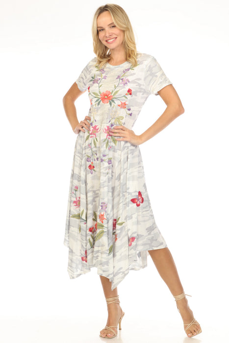 Woman wearing a camouflage midi dress with floral embroidery and handkerchief hem from Johnny Was