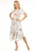 Woman wearing a camouflage midi dress with floral embroidery and handkerchief hem from Johnny Was
