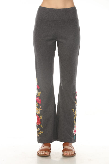 Woman wearing a gray flared high waist leggings with floral embroideries from Johnny Was