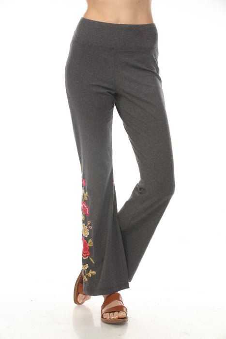 Woman wearing a gray flared high waist leggings with floral embroideries from Johnny Was
