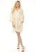Woman wearing a cream-colored shift dress with floral embroidery and a tassel tie v-neck from Johnny Was