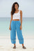 Woman wearing a blue linen pant with cropped barrel leg and embroidered hem from Johnny Was