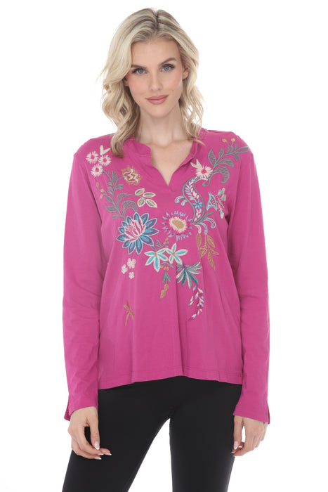 Woman wearing a violet long sleeve top with floral embroidery and split v-neck from Johnny Was