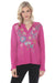 Woman wearing a violet long sleeve top with floral embroidery and split v-neck from Johnny Was