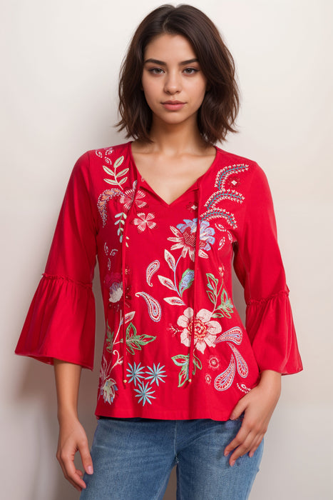 Woman wearing a red embroidered blouse with floral patterns and 3/4 sleeves from Johnny Was