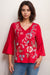 Woman wearing a red embroidered blouse with floral patterns and 3/4 sleeves from Johnny Was