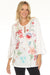 Woman wearing a white top with colorful floral embroidery and 3/4 ruffle sleeves from Johnny Was