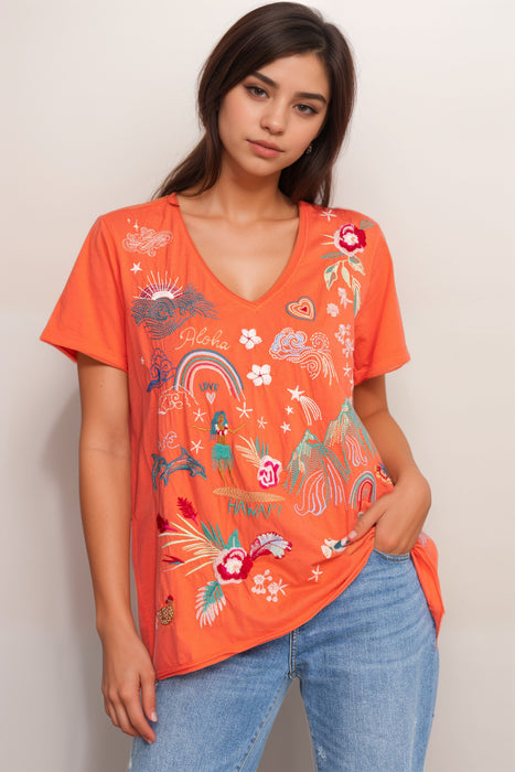 Woman wearing an orange t-shirt with colorful embroideries at the front from Johnny Was