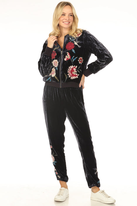 Woman wearing a dark blue velvet jogger pant with floral embroidery from Johnny Was